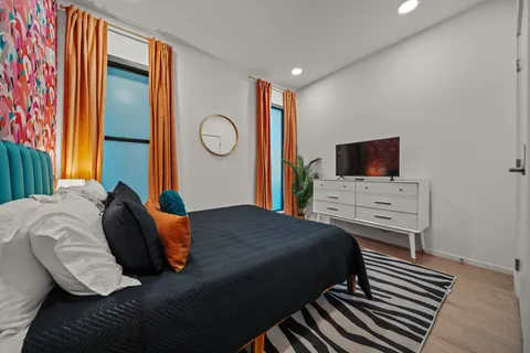 a bedroom with a bed and a flat screen tv