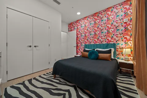 a bedroom with a bed and a painting on the wall