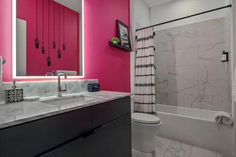 a bathroom with a granite countertop sink a toilet and shower