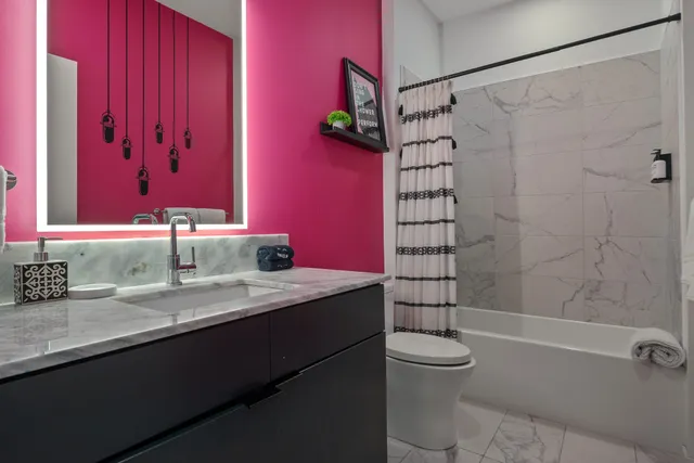 a bathroom with a granite countertop sink a toilet and shower