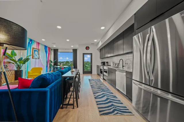 a kitchen with stainless steel appliances granite countertop a refrigerator and a dining table