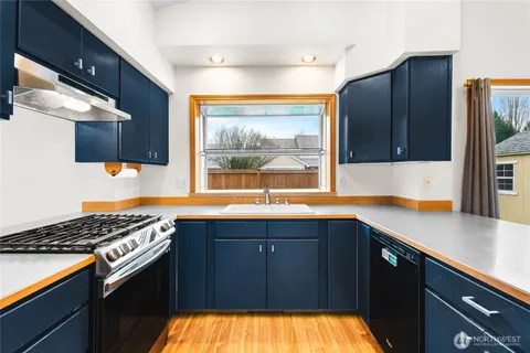 a kitchen with a sink a stove and cabinets