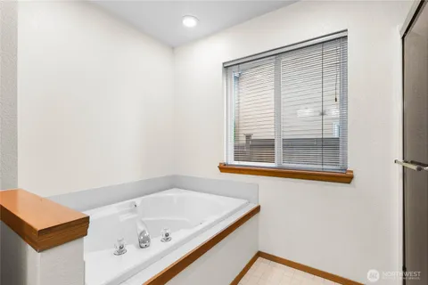 a bathroom with a tub sink and mirror
