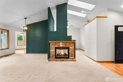 a view of an empty room with window and fireplace