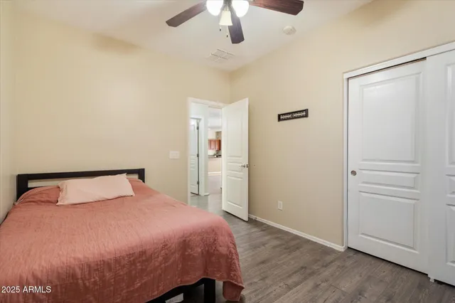 a bedroom with a large bed and wooden floor