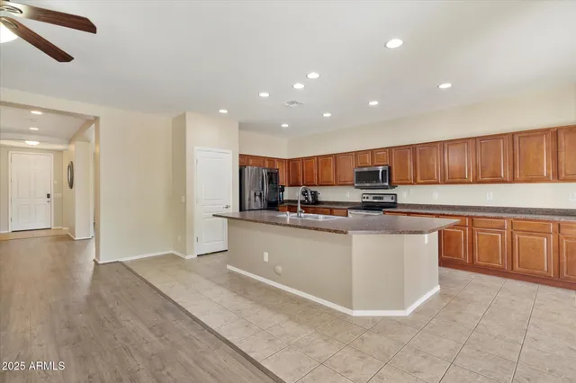 a kitchen with stainless steel appliances granite countertop a refrigerator a sink and a stove