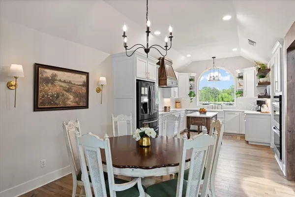 a view of a dining room with furniture a chandelier and wooden floor
