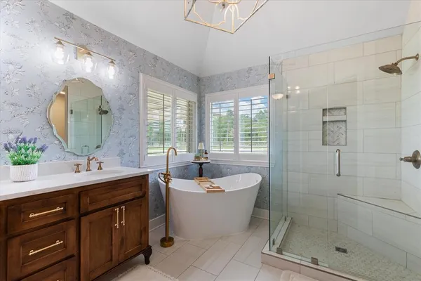 a bathroom with a double vanity sink mirror and bathtub