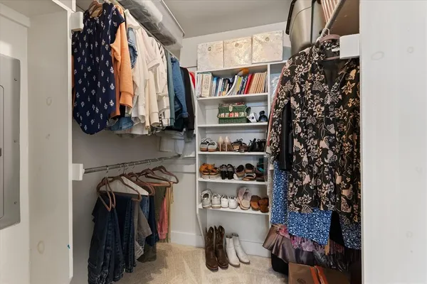a view of walk in closet with clothes and shoes