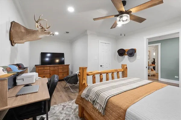 a bedroom with a bed a couch and a flat screen tv