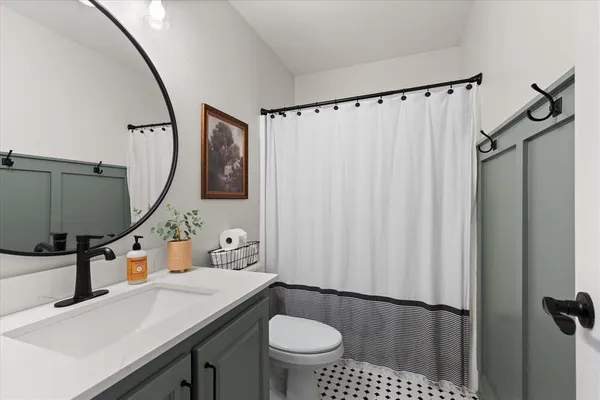 a bathroom with a sink a toilet and a mirror
