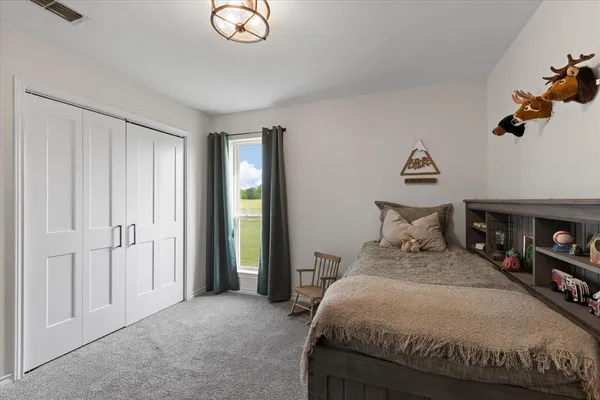 a bedroom with a bed and a chandelier