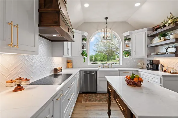 a kitchen with stainless steel appliances granite countertop a sink stove and cabinets