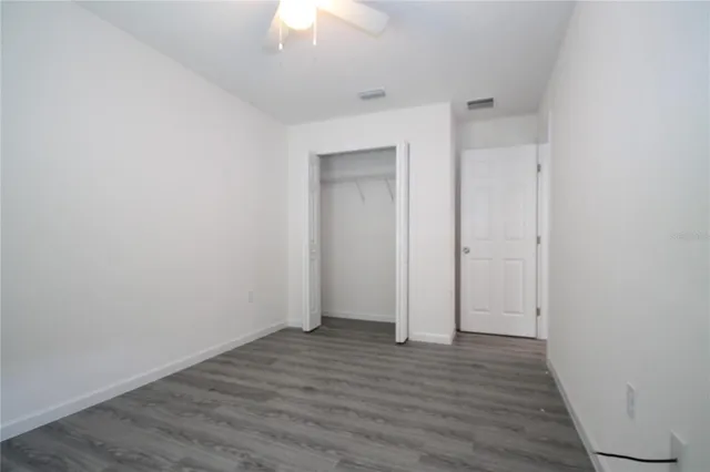 an empty room with wooden floor and closet