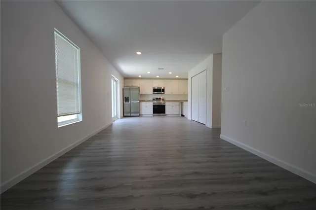 a view of kitchen and hall with wooden floor