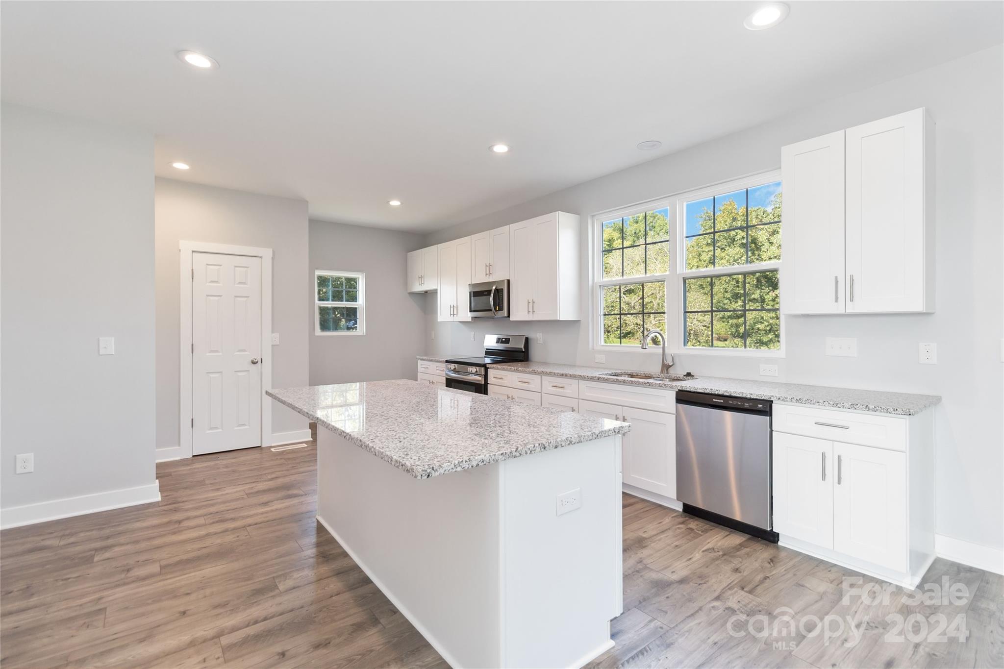 1030 Heath Helms Road Monroe, NC 28110 - Photo 11 of 30 a kitchen with stainless steel appliances granite countertop a sink stove and wooden floor