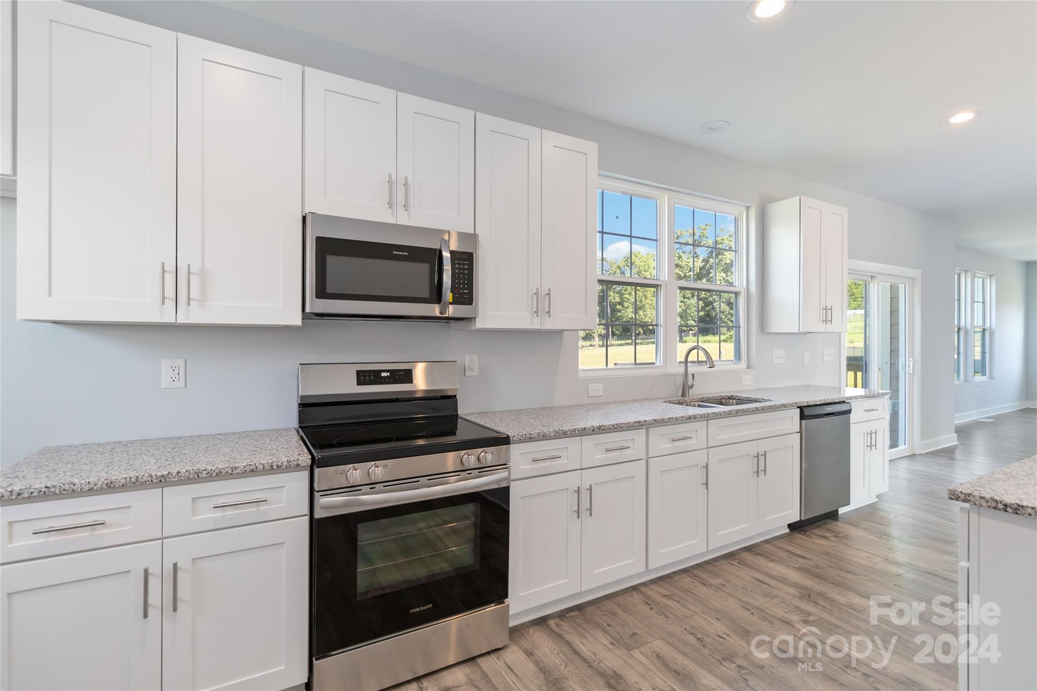 1030 Heath Helms Road Monroe, NC 28110 - Photo 13 of 30 a kitchen with stainless steel appliances granite countertop a stove a sink and a microwave
