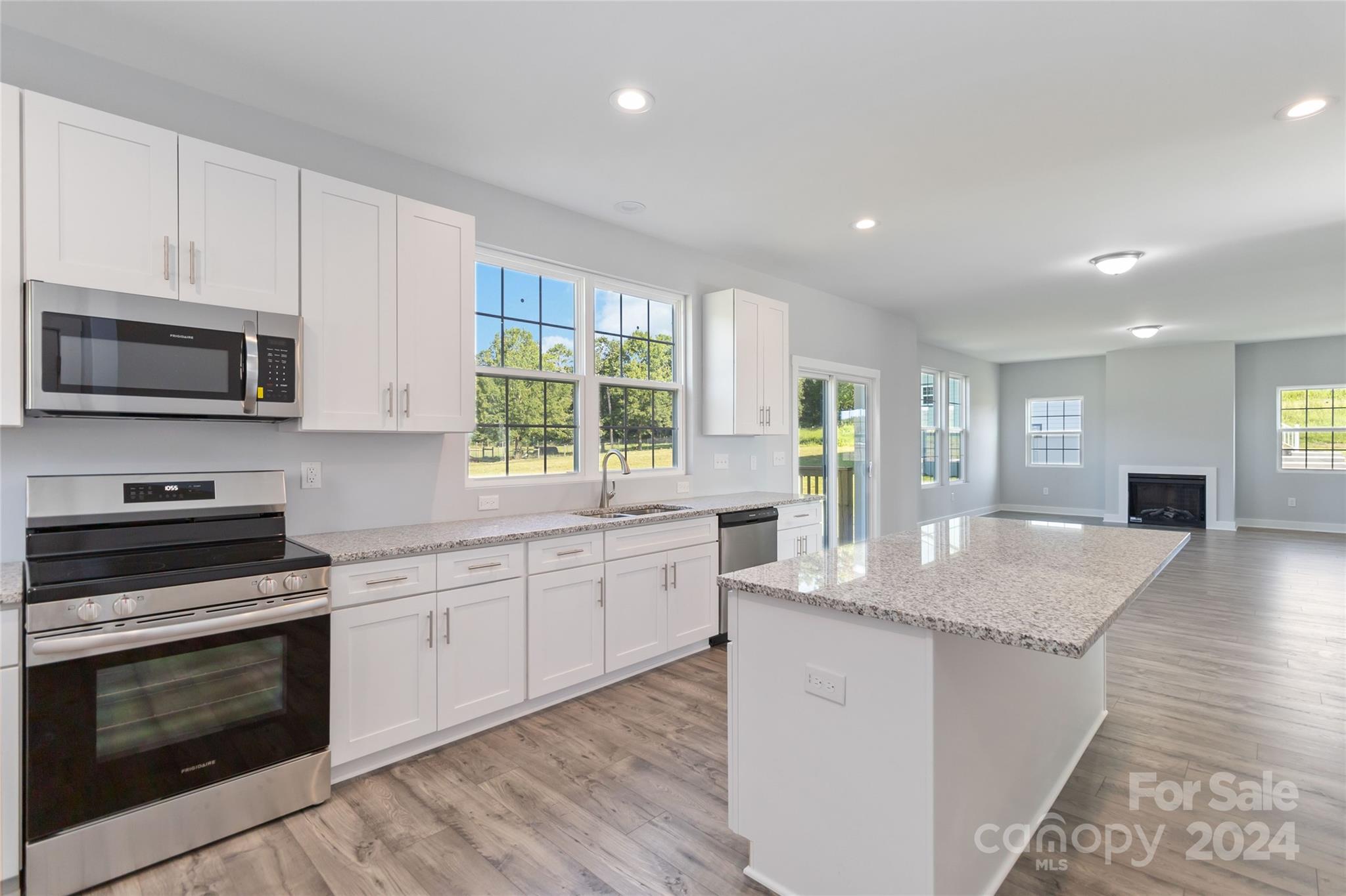 1030 Heath Helms Road Monroe, NC 28110 - Photo 14 of 30 a kitchen with granite countertop a stove top oven sink and cabinets
