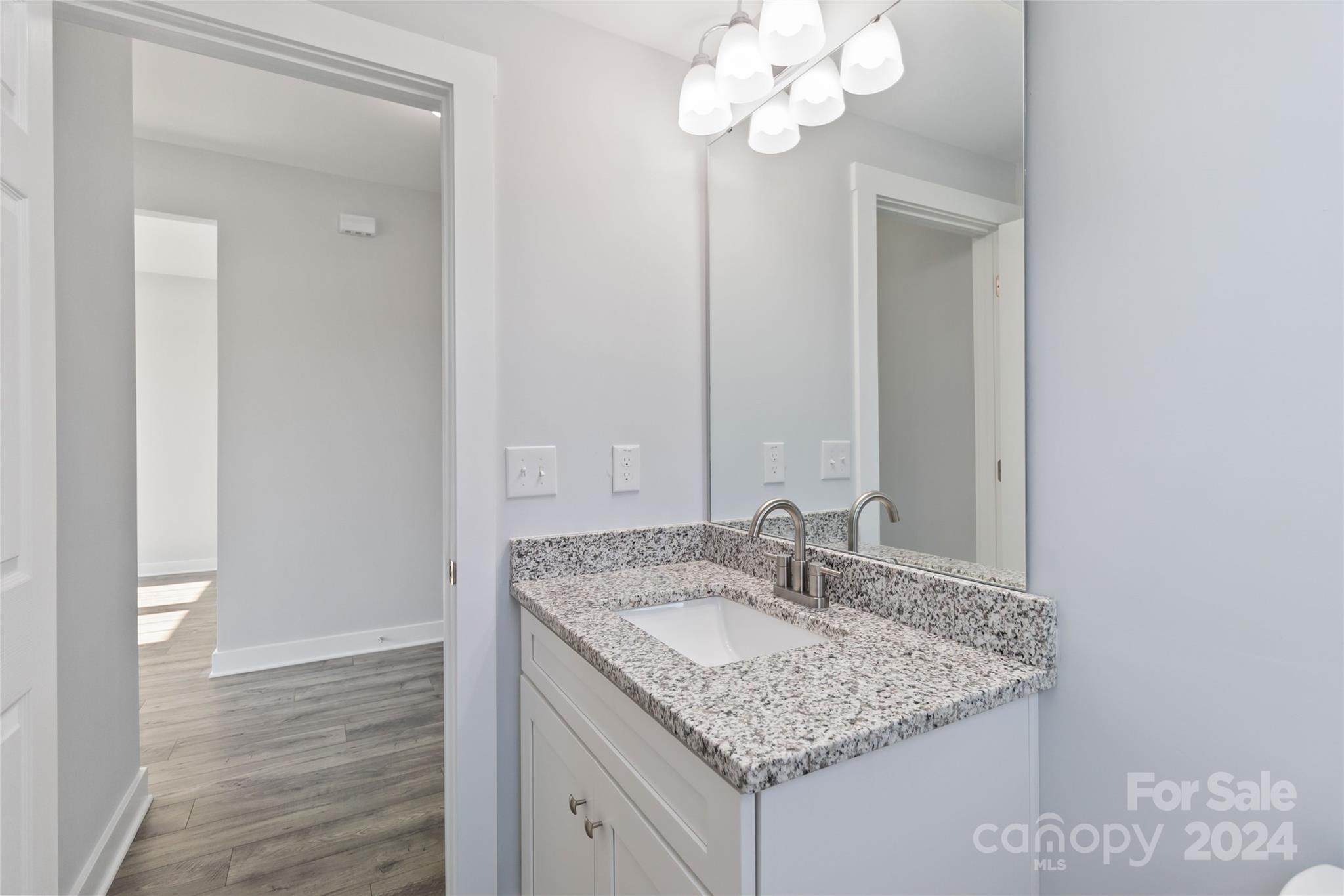 1030 Heath Helms Road Monroe, NC 28110 - Photo 23 of 30 a bathroom with a granite countertop sink a mirror and a vanity