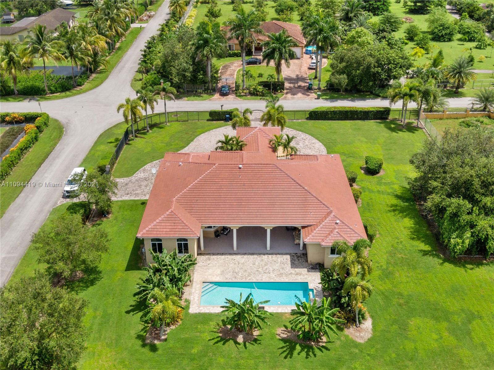 an aerial view of a house with swimming pool patio and lake view