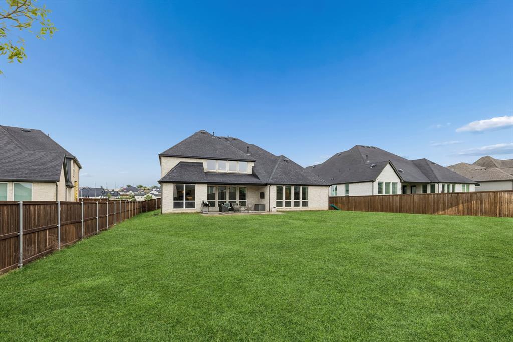 566 Broadleaf Way Haslet, TX 76052 - Photo 34 of 38 Expansive backyard featuring a large green lawn, full privacy fencing, and a rear patio