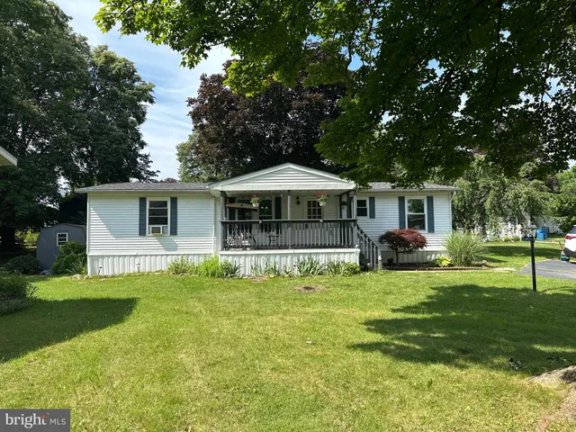 a front view of a house with a yard porch and trees