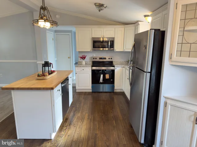 a kitchen with kitchen island granite countertop stainless steel appliances a refrigerator stove top oven and sink