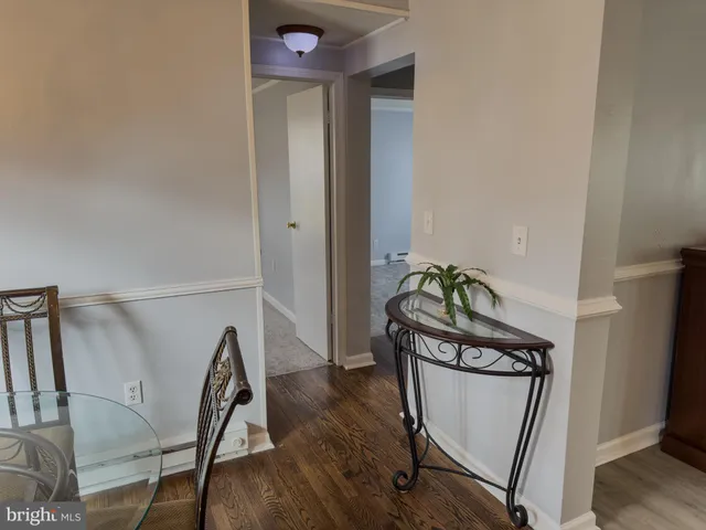 a view of a hallway with wooden floor and a stove