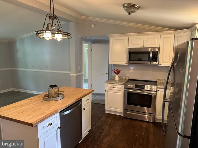 a kitchen with a sink stainless steel appliances and white cabinets