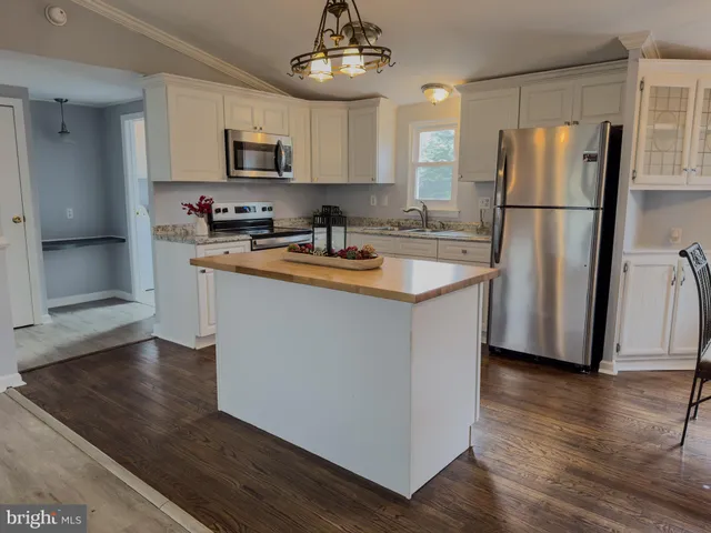 a kitchen with stainless steel appliances granite countertop a refrigerator a stove a sink and a refrigerator