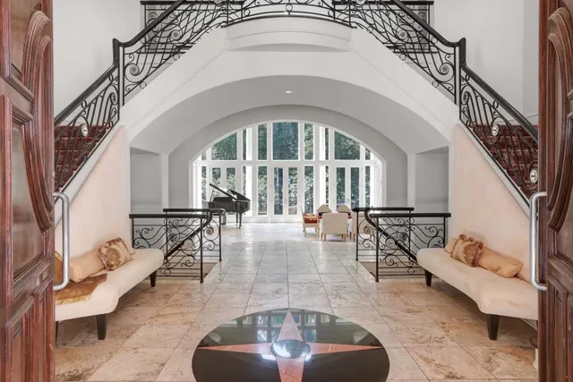 a large bedroom with a balcony a bed and a fireplace