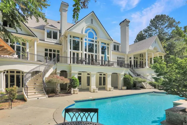 an aerial view of a houses with outdoor space and trees all around