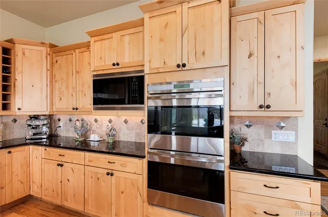 a kitchen with stainless steel appliances granite countertop white cabinets and a stove