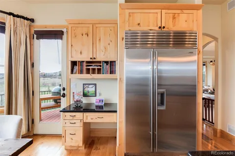 a kitchen with granite countertop a refrigerator and cabinets