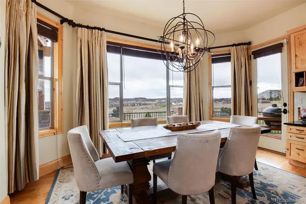 a dining room with furniture large windows and a chandelier