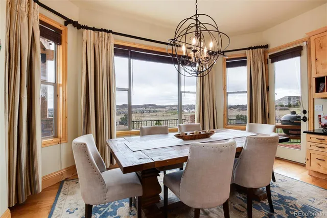 a dining room with furniture large windows and a chandelier