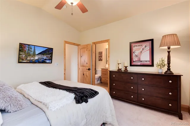 a bedroom with a bed a painting on the wall and a chandelier
