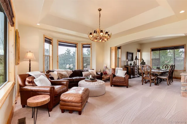 a living room with patio furniture and a chandelier