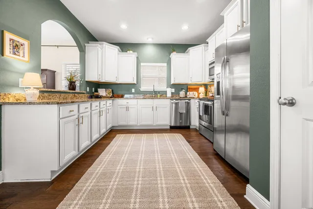 a kitchen with stainless steel appliances granite countertop a sink and cabinets