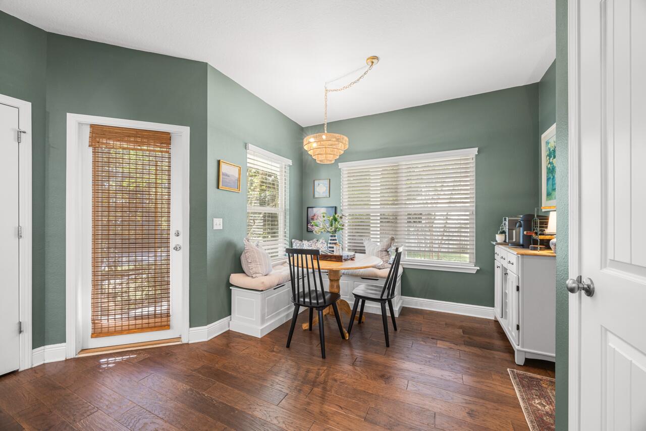 120 Mosaic Oaks Circle Santa Rosa Beach, FL 32459 - Photo 24 of 47 a dining room with wooden floor a chandelier a glass table and chairs