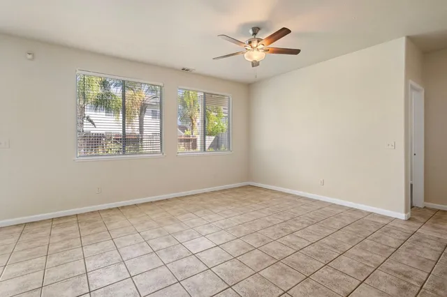 an empty room with windows and fan
