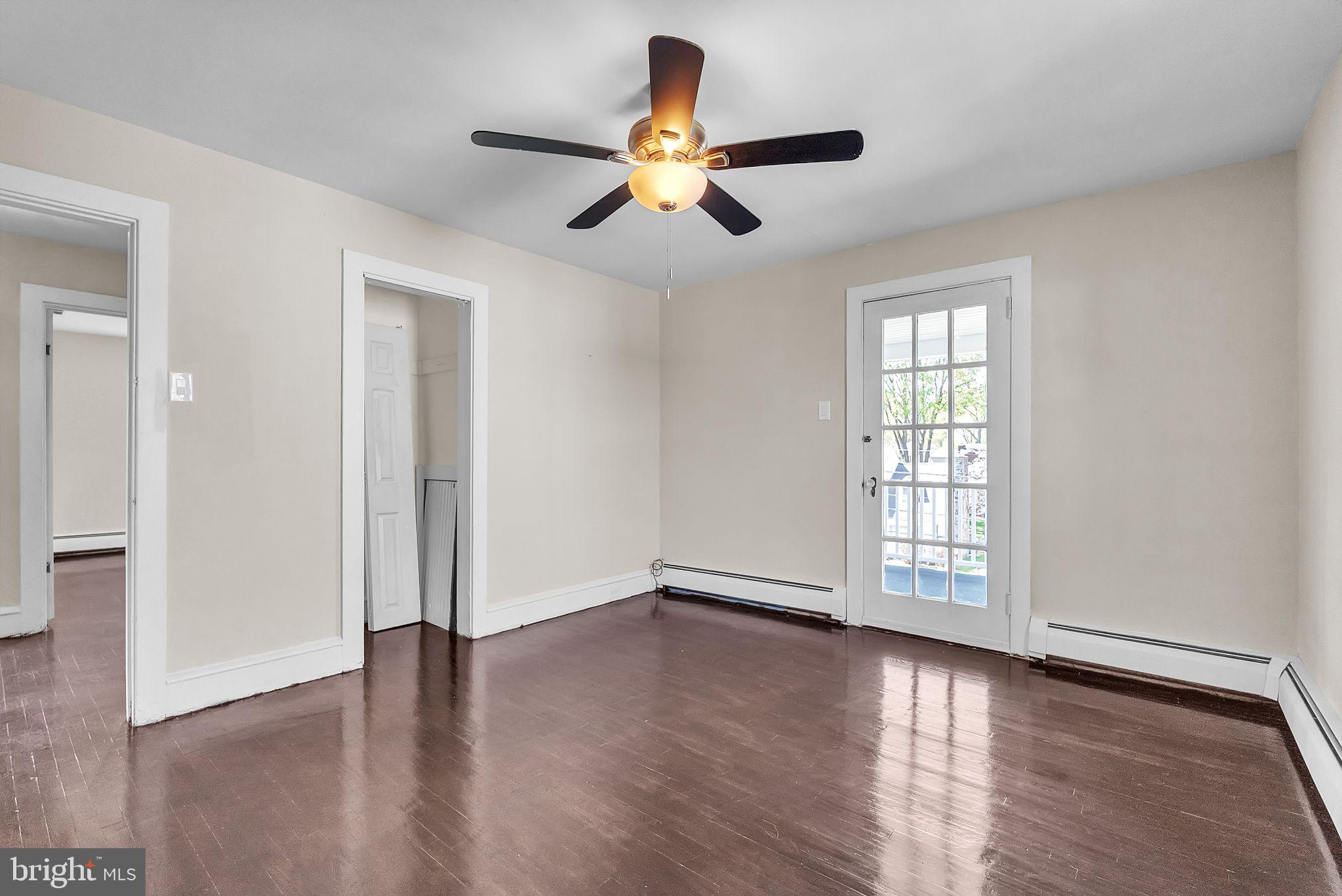107 East Springfield Road Springfield, PA 19064 - Photo 25 of 40 an empty room with wooden floor chandelier fan and windows