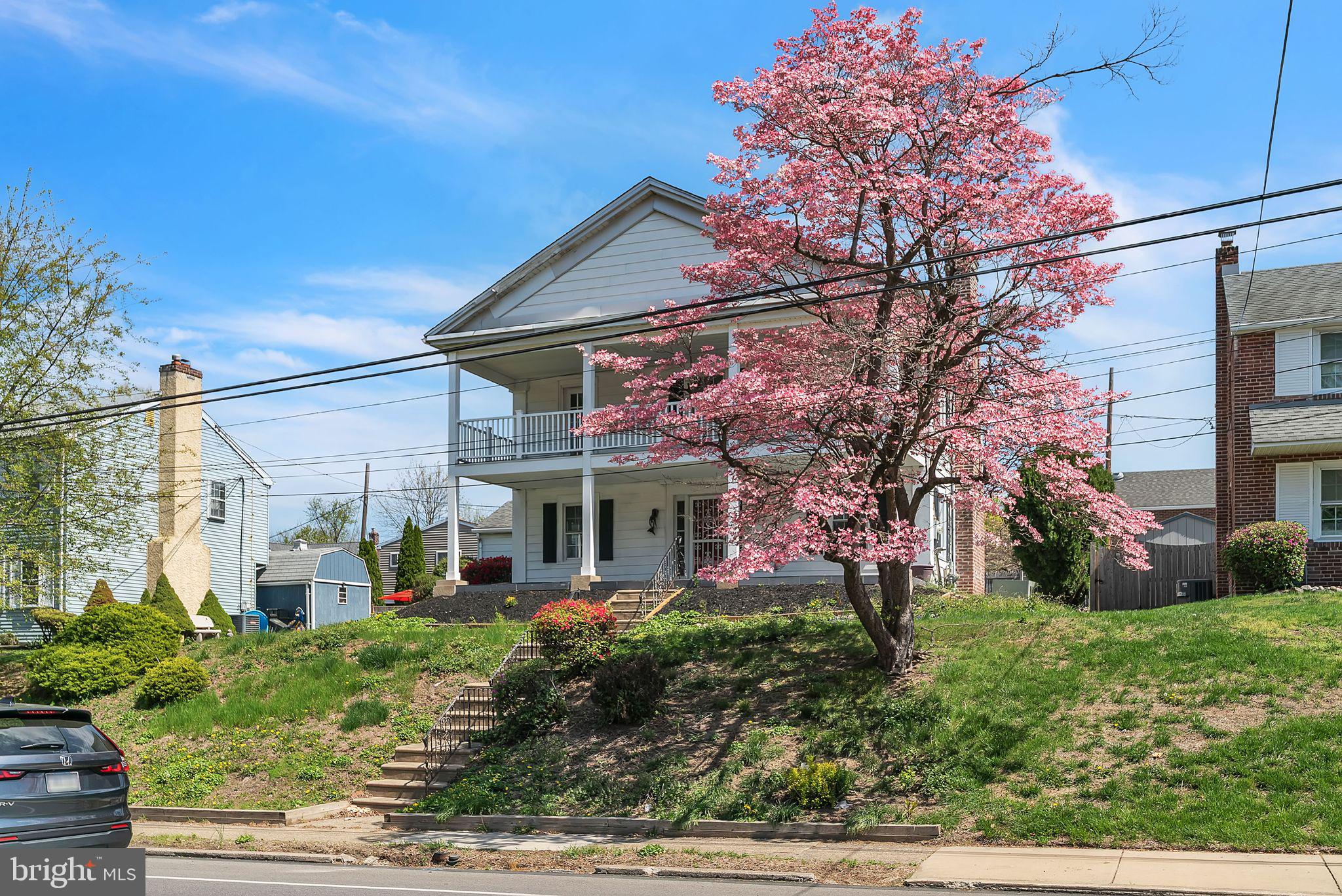 107 East Springfield Road Springfield, PA 19064 - Photo 4 of 40 a view of a house with a small yard plants and large tree