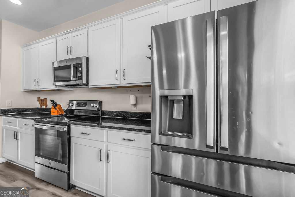 231 Caroline Way Guyton, GA 31312 - Photo 13 of 47 a kitchen with stainless steel appliances granite countertop a refrigerator sink and cabinets
