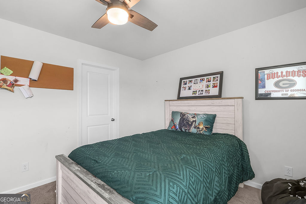 231 Caroline Way Guyton, GA 31312 - Photo 32 of 47 a bedroom with a bed and a chandelier