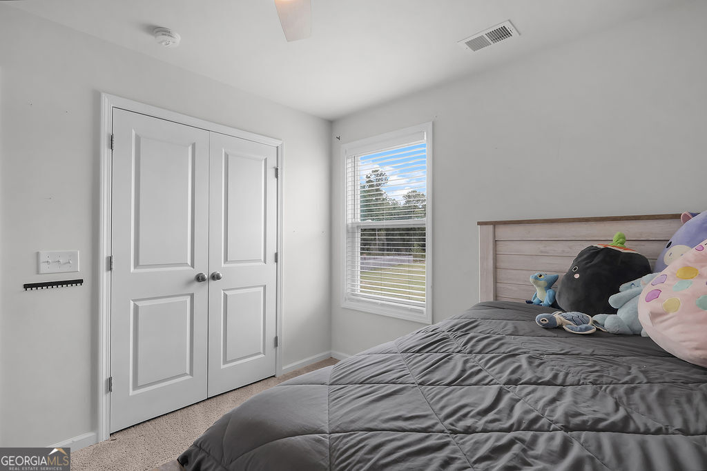 231 Caroline Way Guyton, GA 31312 - Photo 39 of 47 a bedroom with a bed and wooden floor