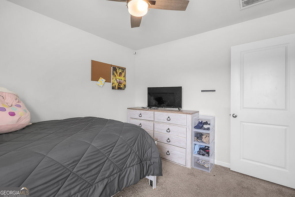 231 Caroline Way Guyton, GA 31312 - Photo 40 of 47 a bedroom with a bed and flat screen tv