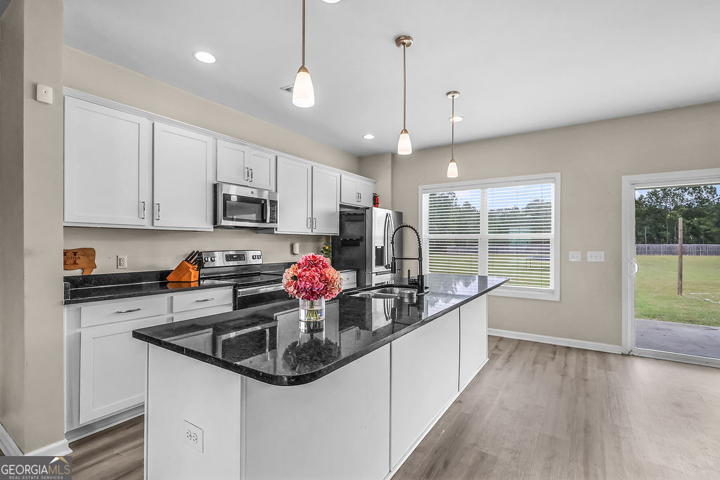 231 Caroline Way Guyton, GA 31312 - Photo 8 of 47 a kitchen with stainless steel appliances a sink a stove and cabinets