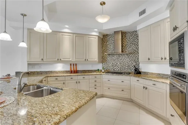 a kitchen with kitchen island granite countertop white cabinets white stainless steel appliances with a sink and dishwasher
