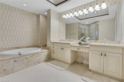 a bathroom with a sink double vanity mirror and a bathtub